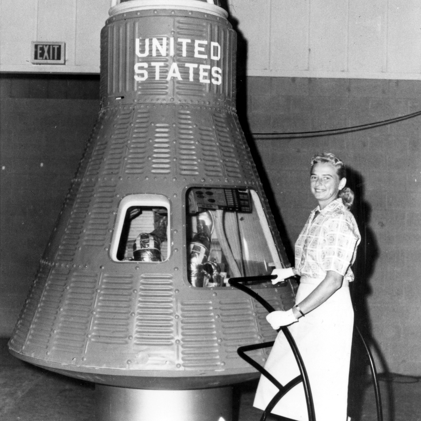 Jerrie Cobb à côté d'une maquette de la capsule Mercury.