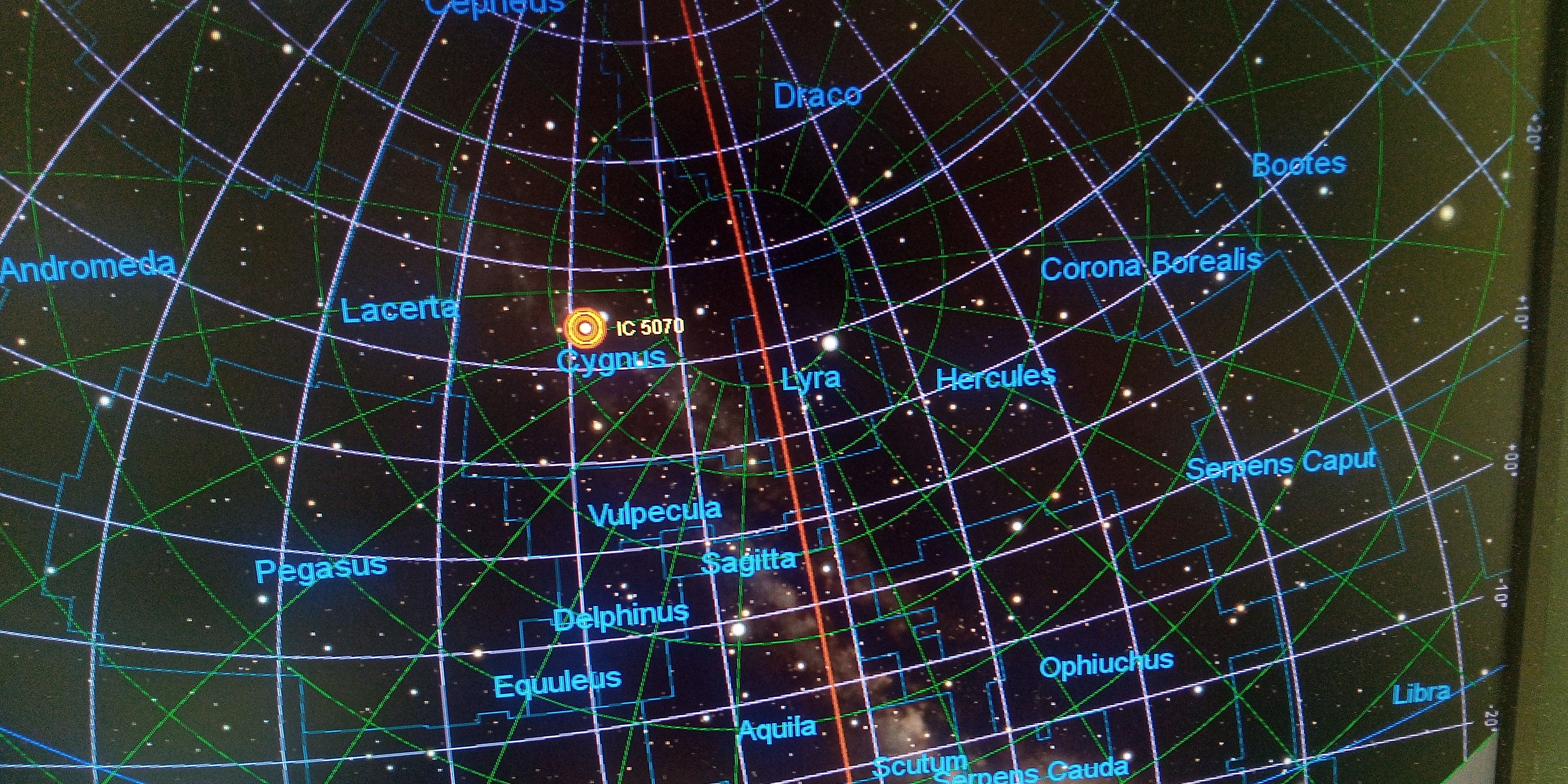 Photo de l'écran avec la carte du ciel du logiciel qui pilote le télescope. La position de la nébuleuse du Pélican est marquée par des cercles jaunes et rouges.